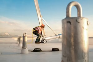 worker setting up davit on roof